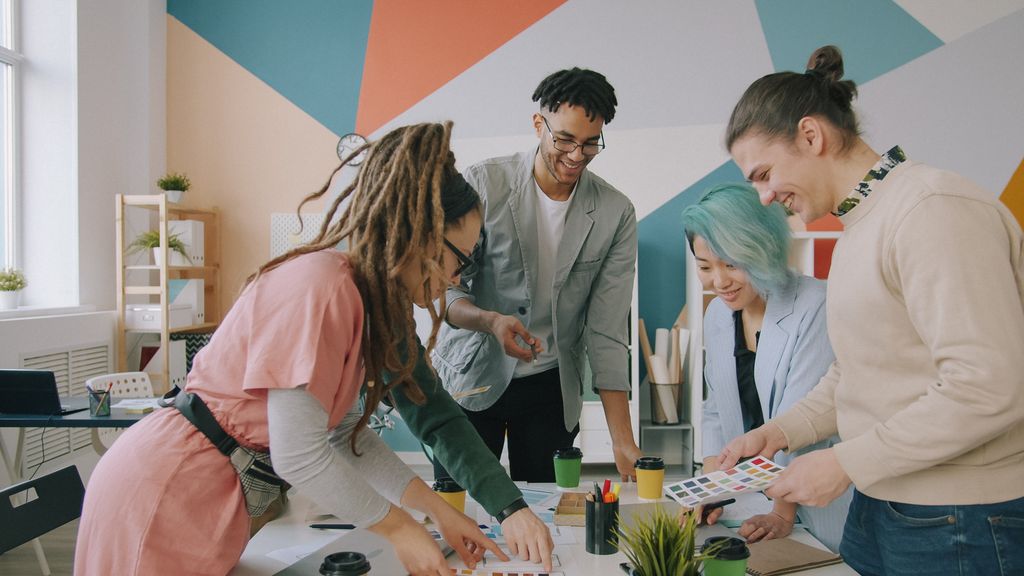 Diverse creative team working together on design project in a modern office environment.