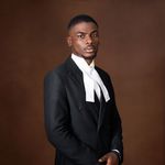 Portrait of African lawyer in a suit with white necktie on brown background.