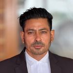 Professional male lawyer in a suit standing outdoors confidently.